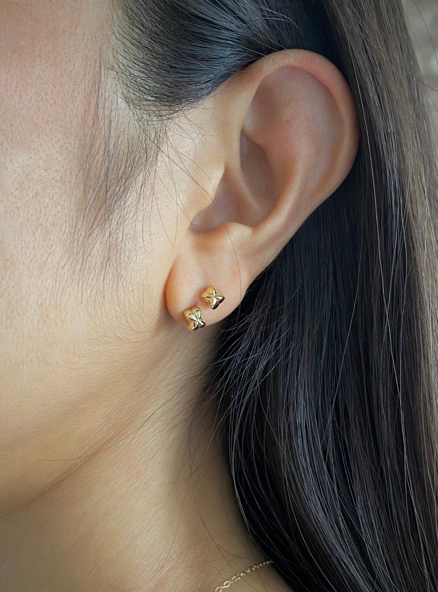 Wearing two of 14 karat yellow gold Love in a Puff plant fruit shaped studs earrings on one ear lobe